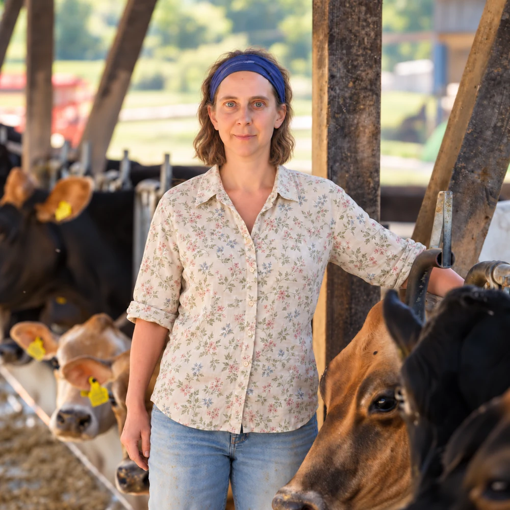Christine Kläusler im Stall des Bio-Paradies, mit blauem Haarband und heller Blumenbluse.